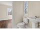 Small bathroom with pedestal sink, toilet, and window at 615 Peach St, Shelby, NC 28150