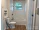 Simple bathroom with a white bathtub, toilet, and wood flooring at 3923 Old Pageland Monroe Rd, Monroe, NC 28112