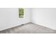Well-lit bedroom with grey carpet and window at 215 Bethesda Rd, Statesville, NC 28677