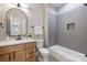 Bathroom with light wood vanity, a tub, and gray tile at 6212 River Birch Dr, Gastonia, NC 28056