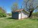 Grey metal barn with large doors, set amongst lush greenery at 112 W Highway 218 Rd, Monroe, NC 28110