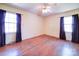 Hardwood floors, ceiling fan, and two windows with curtains at 112 W Highway 218 Rd, Monroe, NC 28110