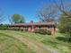 Brick ranch house with a long driveway and spacious yard at 112 W Highway 218 Rd, Monroe, NC 28110