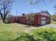 Brick house showcasing a side view with garage and yard at 112 W Highway 218 Rd, Monroe, NC 28110