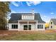 Stunning white farmhouse exterior with a covered patio and large backyard at 19413 Coachmans Trce, Cornelius, NC 28031