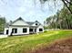 White farmhouse with black accents, nestled on a spacious lot with mature trees at 3860 Nc Hwy 200 Hwy, Concord, NC 28025