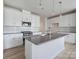 Modern kitchen with white cabinets, gray countertops, and an island at 8915 Nettleton Ave, Charlotte, NC 28215