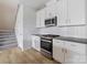 Modern kitchen with white cabinets, gray countertops, and stainless steel appliances at 8915 Nettleton Ave, Charlotte, NC 28215