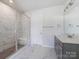 Bathroom with marble shower, gray vanity, and modern fixtures at 8915 Nettleton Ave, Charlotte, NC 28215