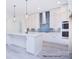 Spacious kitchen with white cabinets, blue hex tile backsplash, and island at 106 Windbluff Ct # 163, Statesville, NC 28677