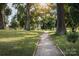 Paved walkway through a sunny park with lush green grass and trees at 1039 Canando St, Charlotte, NC 28214