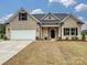 Front view of a beige brick house with a white garage door at 1005 Piper Meadows Dr # 1, Waxhaw, NC 28173