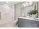 Bathroom with gray vanity, marble shower, and modern fixtures at 130 Cherokee Rd # 102, Charlotte, NC 28207
