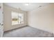 Bright bedroom with gray carpeting and a large window at 107 S Dunlavin Way # 63, Mooresville, NC 28115