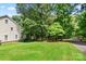 Landscaped side yard with mature trees and a paved pathway at 205 Vauxhall Dr, Shelby, NC 28150