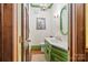 Charming powder room with green vanity and decorative wallpaper at 205 Vauxhall Dr, Shelby, NC 28150