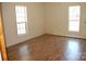 Simple bedroom with two windows and wood-look flooring at 710 Austin St # 124, Albemarle, NC 28001