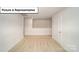 Open loft area with neutral carpeting and a door at 7765 Woolsey Dr, Gastonia, NC 28056