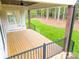 Covered deck with wooden flooring, metal railings, and wooded backyard view at 7362 Hemlock Ct, Denver, NC 28037