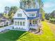 Two-story white farmhouse with gray roof, landscaping, and a paved driveway at 7362 Hemlock Ct, Denver, NC 28037