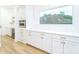 White kitchen cabinets and quartz countertops with wine fridge at 7362 Hemlock Ct, Denver, NC 28037