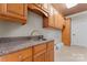 Laundry room with wooden cabinets, granite countertop, and utility sink at 590-0 Tuckertown Rd, New London, NC 28127