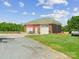 View of a detached brick garage with a seating area, and basketball hoop at 4809 Us 74 Hwy, Wingate, NC 28174