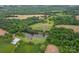 Aerial view showcasing a pond, outbuildings, and lush green pasture at 24686 Barbees Grove Rd, Oakboro, NC 28129