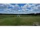 Spacious backyard with a small shed, under a bright sunny sky at 24686 Barbees Grove Rd, Oakboro, NC 28129