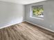 Bright bedroom with a large window and wood-look floors at 3021 Heathstead Pl # D, Charlotte, NC 28210
