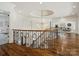 Elegant upper hall with curved staircase, chandelier, and hardwood floors at 9044 Island Point Rd, Charlotte, NC 28278
