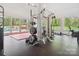 State-of-the-art home gym with extensive equipment and pool view at 9044 Island Point Rd, Charlotte, NC 28278