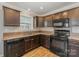 Dark wood cabinetry, granite countertops, and stainless steel appliances in this kitchen at 159 Badin Lake Cir, New London, NC 28127