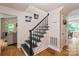 Elegant staircase with black spindles and hardwood floors leading to the upper level at 15016 Rocky River Rd, Davidson, NC 28036