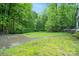 Spacious backyard with grassy area, stone patio, and mature trees at 15016 Rocky River Rd, Davidson, NC 28036