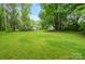 Large backyard with green grass and distant view of house at 15016 Rocky River Rd, Davidson, NC 28036