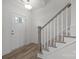 Bright entryway with wood-look floors, white door, and staircase with gray railing at 280 Supernova Dr, York, SC 29745