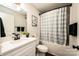 Clean bathroom with a white vanity, checkered shower curtain, and tub at 539 N C Ave, Maiden, NC 28650