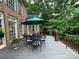 Spacious deck with a dining table set and umbrella, overlooking a wooded area at 500 Muirfield Dr, Albemarle, NC 28001