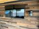 Outdoor screened porch with mounted TV and wood wall at 150 Marina Dr, New London, NC 28127