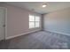 Simple bedroom with gray carpet, a window, and a door at 1016 Forest Dr, Marshville, NC 28103