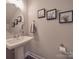 Modern powder room with pedestal sink, oval mirror, and framed art at 1016 Forest Dr, Marshville, NC 28103