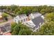 Aerial view of modern townhouses with tree-lined street and city skyline in the background at 1411 Collier Walk Aly # Csw0105, Charlotte, NC 28205