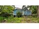 Side view of a blue house with overgrown vegetation at 118 Summit Ave, Albemarle, NC 28001