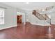 Spacious living room with hardwood floors and open views to the kitchen and staircase at 509 Pine Needle Ct, Weddington, NC 28104
