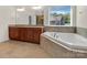 Bathroom boasts double vanity, granite countertop, and corner tub at 509 Pine Needle Ct, Weddington, NC 28104