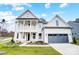 Two-story farmhouse-style home with gray garage doors and a front porch at 2003 Cedar Falls Dr # 69, Waxhaw, NC 28173