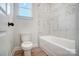 Bathroom with a bathtub, marble tile, and a toilet at 2004 Cedar Falls Dr # 4, Waxhaw, NC 28173