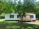 White single-story manufactured home with black shutters and a wooden deck at 7067 Citation St, York, SC 29745