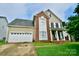 Two story house with a brick and beige exterior, and a two car garage at 9841 Baxter Caldwell Dr, Charlotte, NC 28213